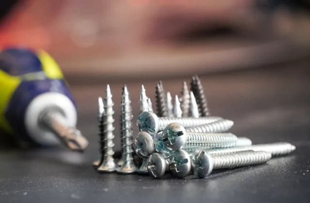 Desarmador y un montón de tornillos sobre una mesa
