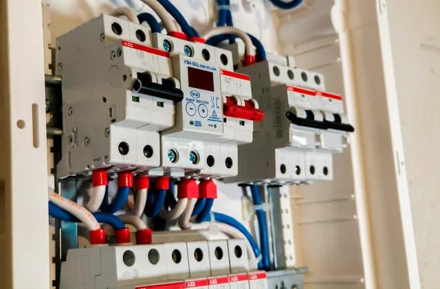 Daire elektrik panosunda yan yana dizilmiş otomatik sigortalar, kaçak akım rölesi ve dijital göstergeli bir gerilim koruma rölesi