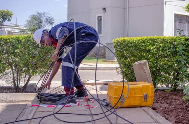 Un électricien accroupi préparant des câbles sur un chantier
