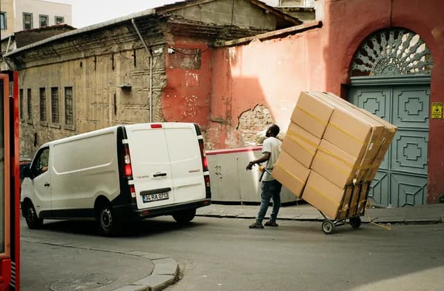 Un livreur déchargeant des cartons d’une camionnette dans une rue