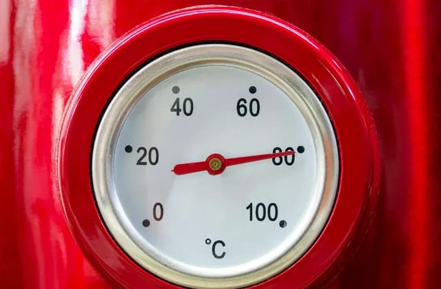 Thermomètre à cadran sur le corps rouge d’une chaudière