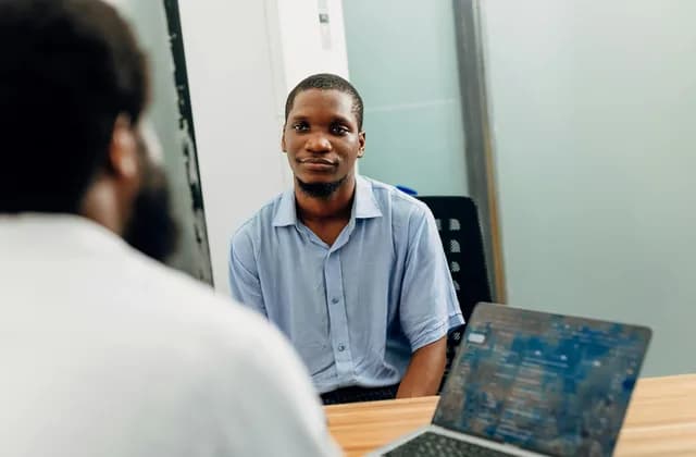 An employer interviewing a candidate across a desk