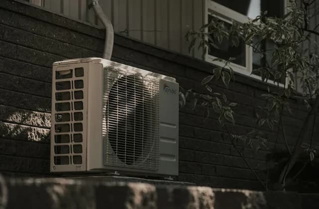 Condensadora de ar-condicionado split instalada junto a uma parede de tijolos