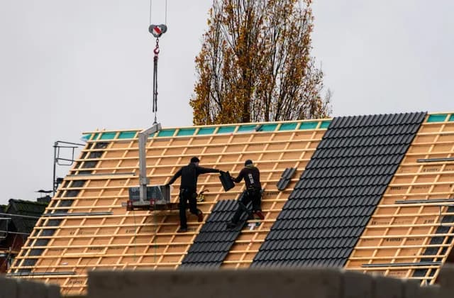 Couvreurs posant une nouvelle couverture sur une toiture en pente