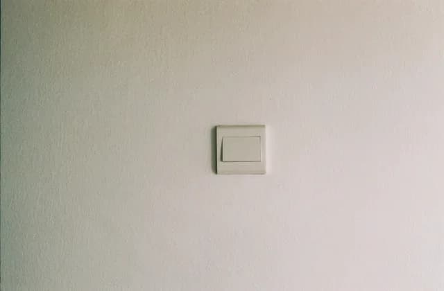 Un interrupteur blanc posé sur un mur clair