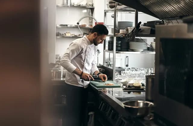 Cozinheiro finalizando pratos na cozinha de um restaurante