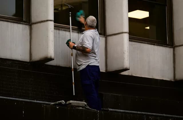 Window cleaner using an extension pole on an upper-floor window