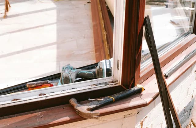 Hammer and drill on a window sill during window installation