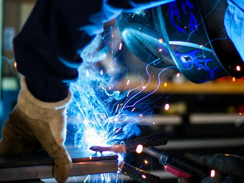 Kıvılcımlar saçarak metal üzerinde çalışan bir kaynakçı