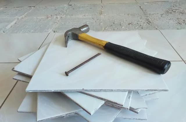 Martelo e pilha de azulejos brancos prontos para o assentamento