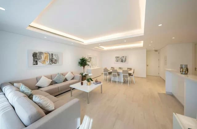 Gizli LED aydınlatmalı asma tavanı olan, köşe koltuklu geniş ve aydınlık bir salon