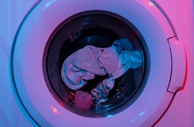 Hublot d’un lave-linge avec du linge à l’intérieur